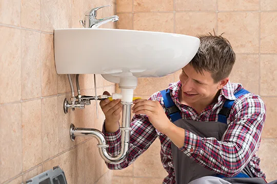 Plumber working on bathroom plumbing and waste pipework in Mansfield