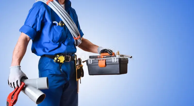 Plumber in uniform carrying tools and pipework for an emergency call out